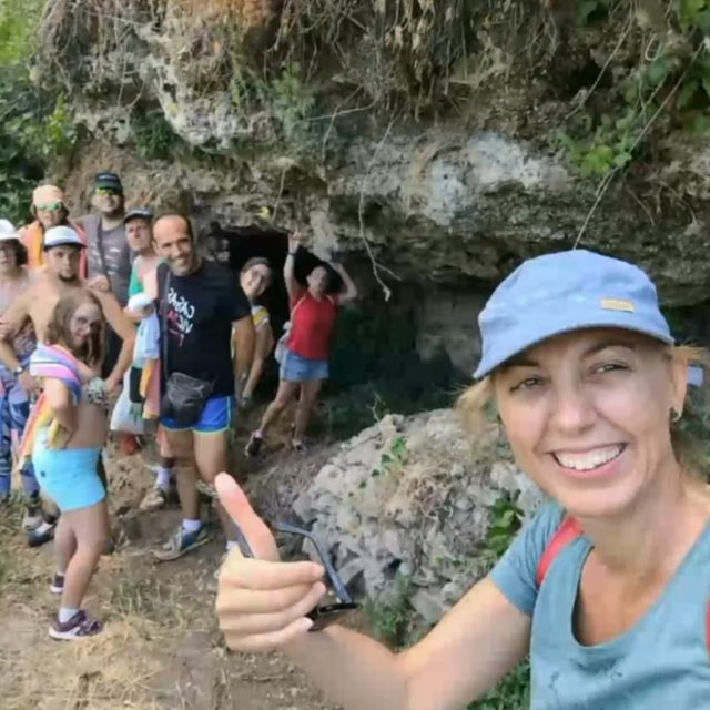 grupo de personas posando junto a una roca